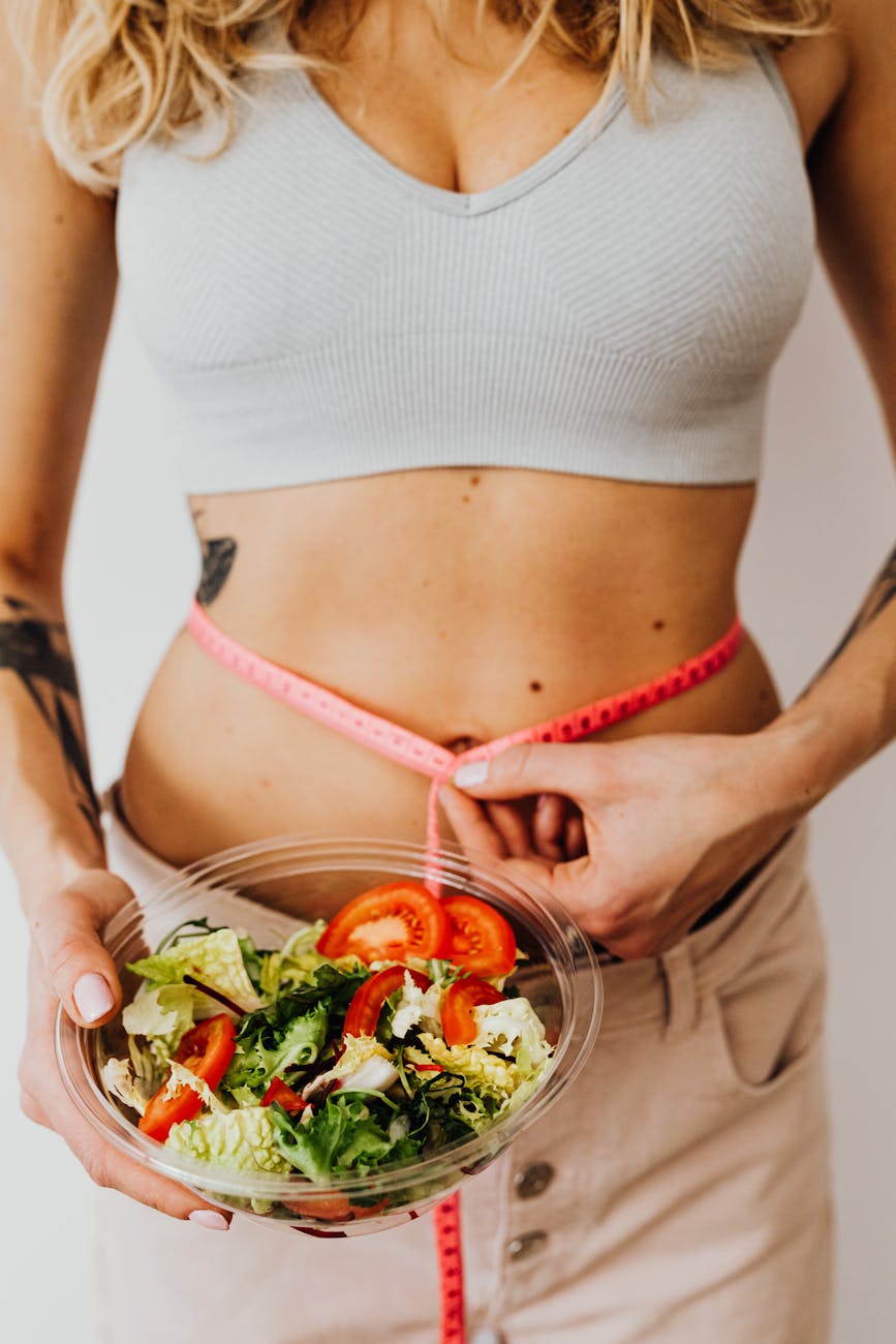 Woman tracking healthy eating habits and waist measurement as part of a medically supervised weight loss program